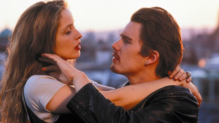 A man and woman are holding each other, maintaining eye contact.